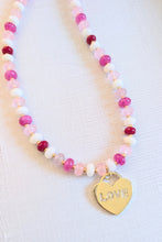 Load image into Gallery viewer, Necklace with pink beads and a gold 'LOVE' heart charm on a light background